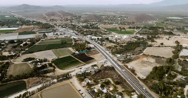 Scenic aerial view of El Pescadero, BCS, Mexico showcasing farmland, roads, and mountains.