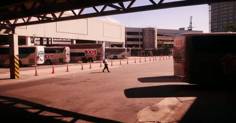 Busy bus terminal in Rio de Janeiro, captured at midday with visible transportation activity.