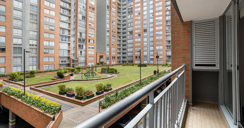 A view of a modern apartment complex from a balcony overlooking a playground area.