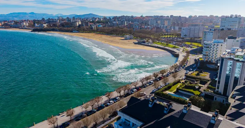Stunning aerial view of El Sardinero Beach in Santander, Spain with vibrant coastline and urban architecture.
