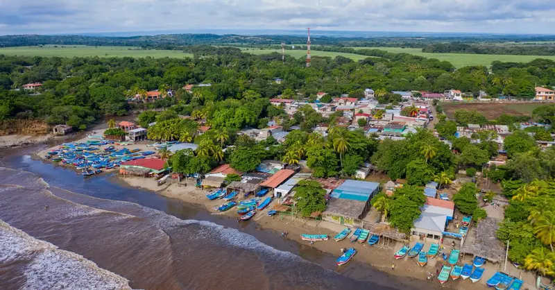 Scenic aerial view of a vibrant coastal town in Nicaragua with colorful boats and lush greenery.