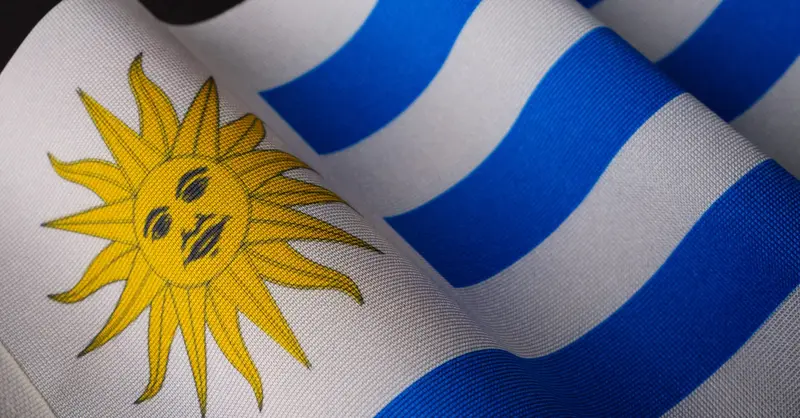 Detailed view of the Uruguayan flag showcasing the sun emblem and blue stripes.