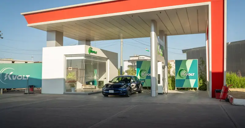A sleek electric car charging at a modern station with blue skies in the background, promoting eco-friendly travel.