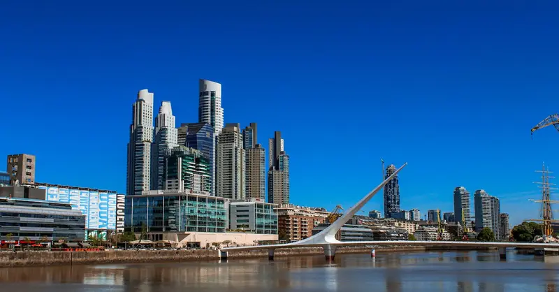 Striking skyline view of Buenos Aires with Puente de la Mujer and modern high-rise buildings on a sunny day.
