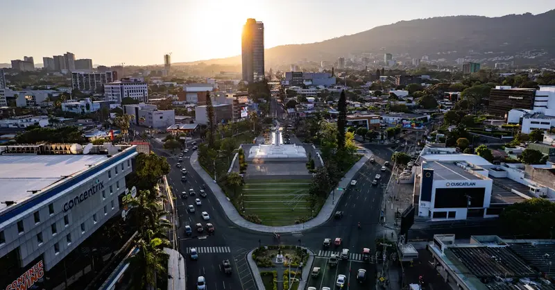 A captivating aerial view of San Salvador at sunrise featuring modern buildings and bustling streets.