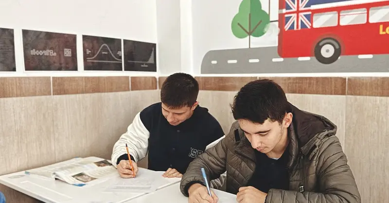 Two students focused on study materials in a London-themed classroom setting.