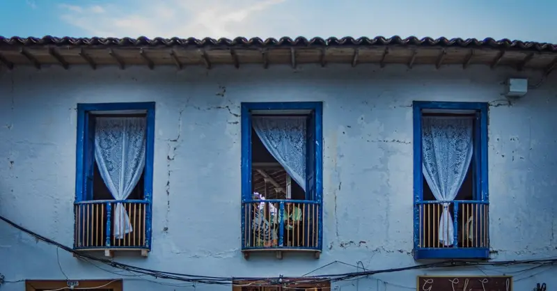 Charming colonial building facade in a Colombian town with blue-framed windows.