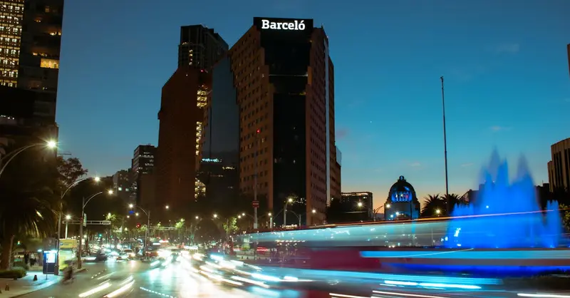 A dynamic long exposure shot of vibrant nighttime traffic in Ciudad de México with city lights.
