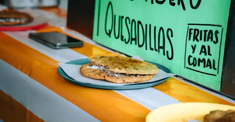 Delicious Mexican quesadilla served on a plate at a street food stand in Mexico City.