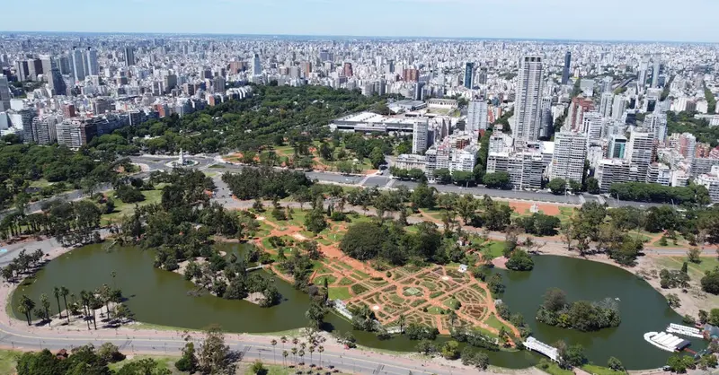 Aerial view showcasing Buenos Aires skyline with lush parks and water features in the foreground.