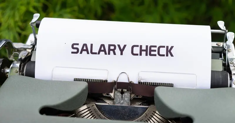 Close-up of a vintage typewriter typing 'Salary Check' on paper, symbolizing payroll and finance.