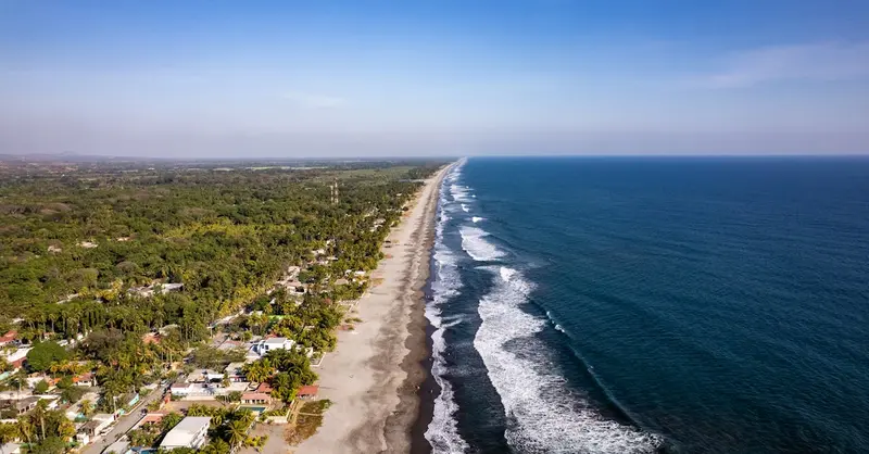 Stunning aerial view of La Libertad's coastline in El Salvador, capturing the vibrant beach and surrounding landscape.