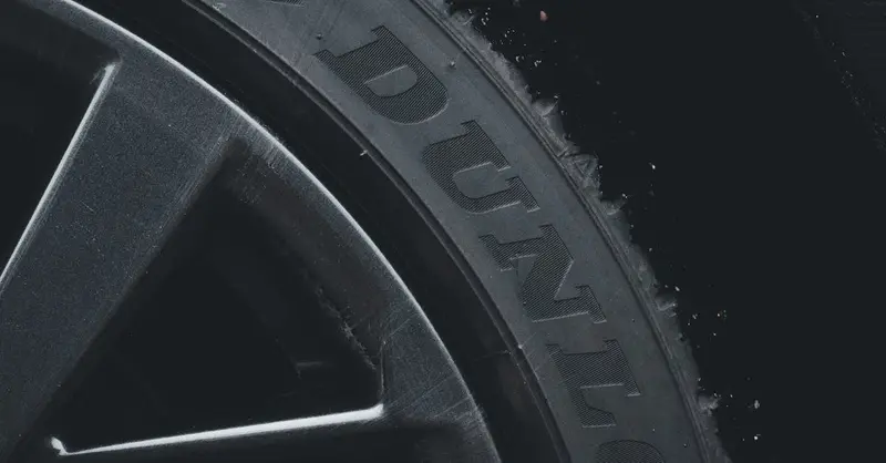Detailed close-up of a Dunlop tire and rim showcasing its texture and brand text.