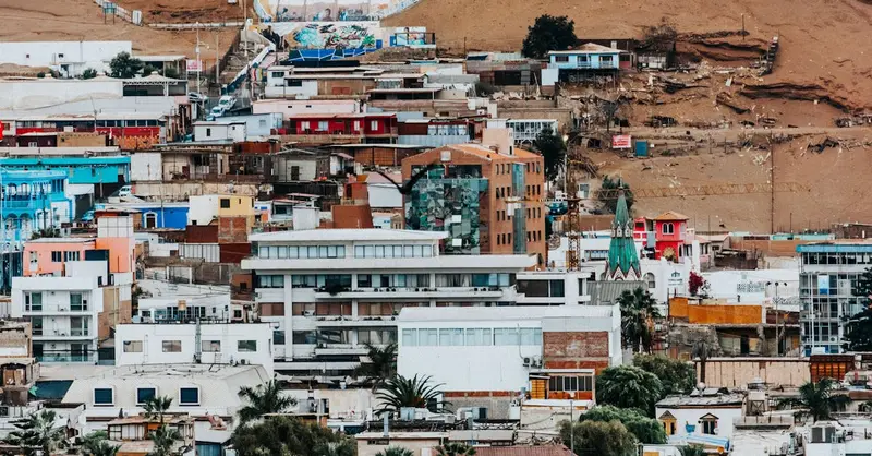 Colorful hillside houses and architecture in Arica, Chile, with desert backdrop.