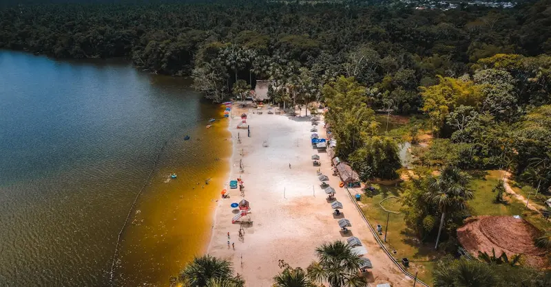 Stunning aerial shot of a beach on Laguna Quistococha, surrounded by lush forest in Iquitos, Peru.