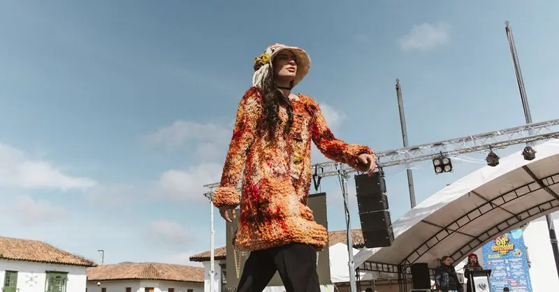 Model walking in vibrant fashion during an outdoor event in Tunja, Colombia.