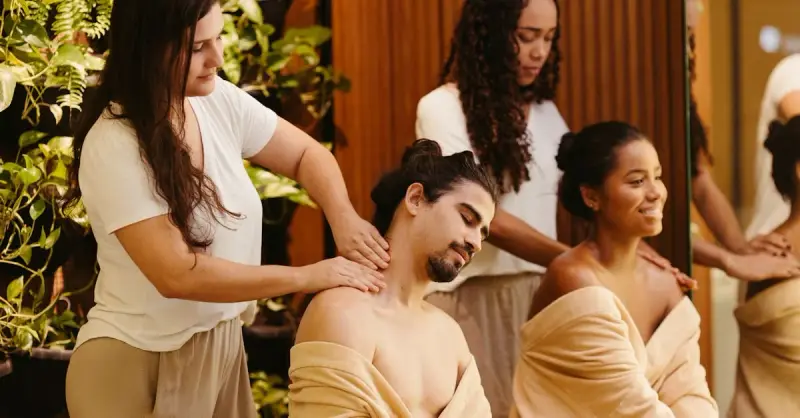 Men and women enjoying relaxing massages at a spa, surrounded by greenery, promoting wellness and relaxation.