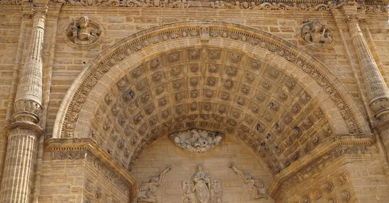 Intricate facade of the Santa Maria de la Mesa Cathedral in Utrera, Spain, showcasing Gothic architecture.