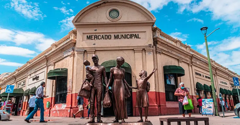 Explore Mercado Municipal with bronze statues in front, capturing everyday life in Mexico.
