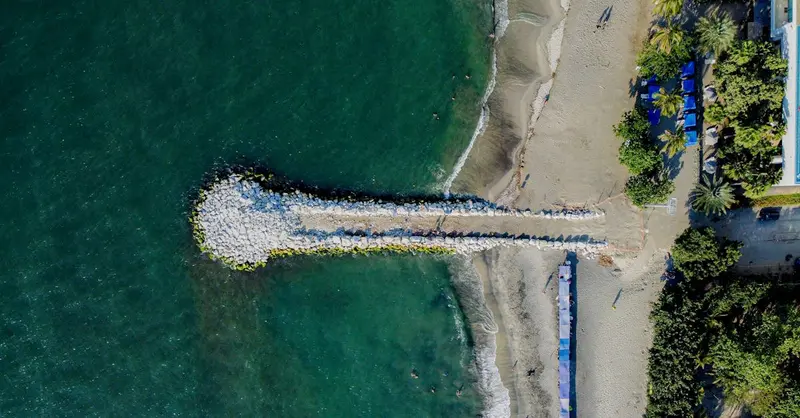 Aerial shot of Santa Marta beach, Colombia with a pier extending into the sea.