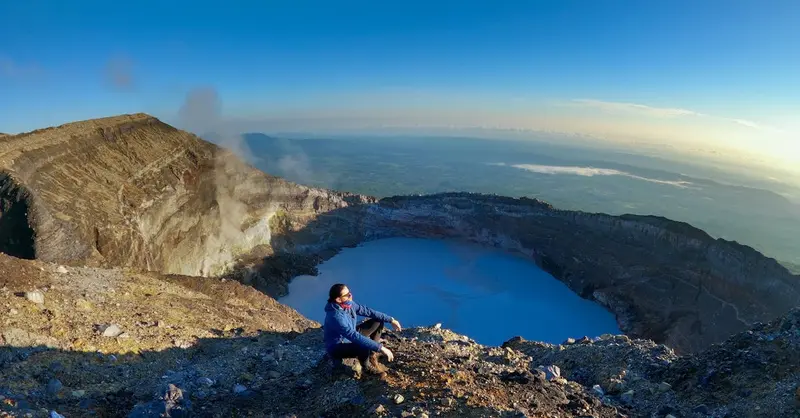 A person enjoys the breathtaking view from the top of Rincón de la Vieja Volcano, Costa Rica.