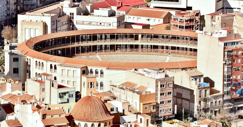 Aerial view of the Alicante bullring surrounded by urban architecture, showcasing the cityscape of Alicante, Spain.