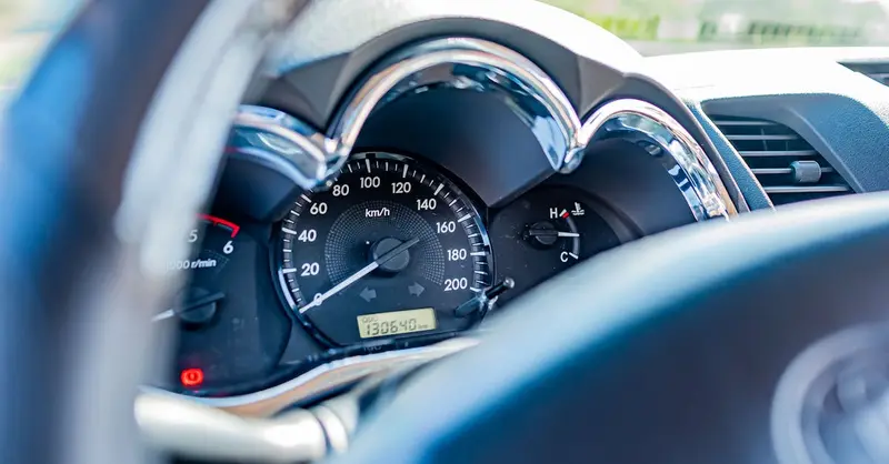 Detailed view of a car's speedometer and gauges from the driver's seat, highlighting instrument clarity.