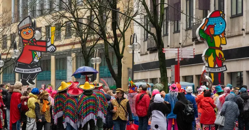 Vibrant street celebration during Cologne's famous carnival festival with attendees in colorful costumes and parade floats.