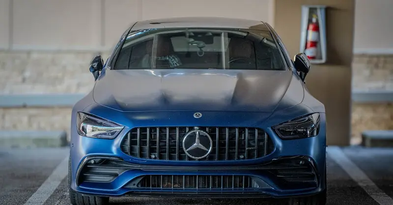 Front view of a stylish blue Mercedes parked in a Naples, Florida indoor location.