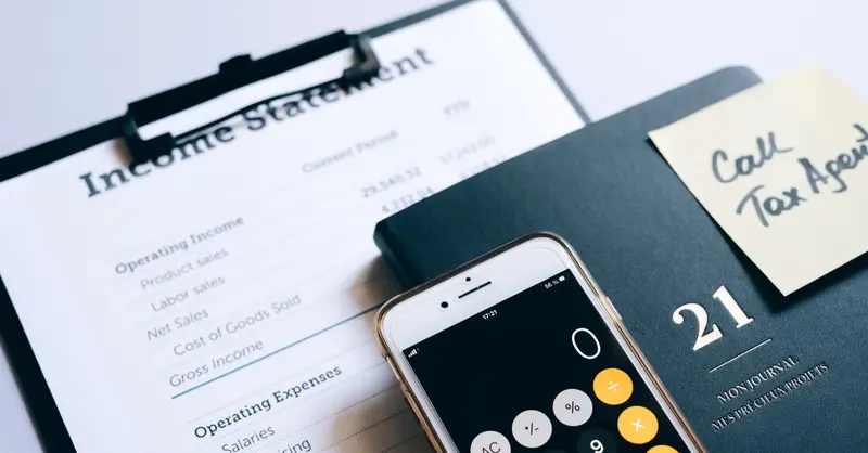 Close-up of income statement, calculator, and planner for financial planning.