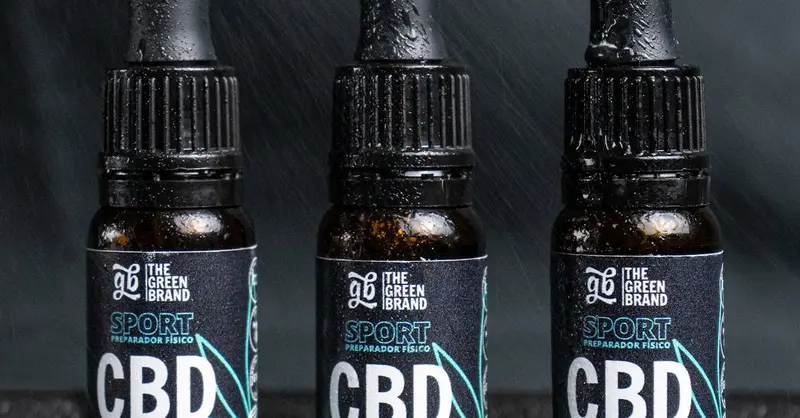 Close-up of three CBD oil bottles labeled for sports recovery and fitness.