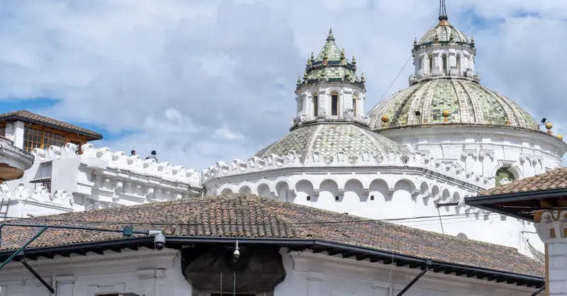 Beautiful view of historic church domes under a bright blue sky in Quito, Ecuador.