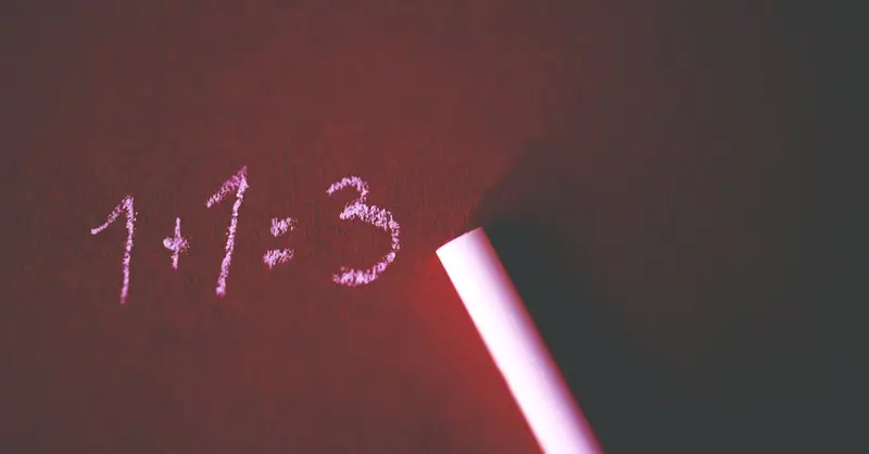 Close-up of a chalkboard with a humorous math error showing 1+1=3 written in chalk.