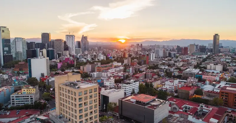 A breathtaking aerial view of Mexico City's skyline during sunset, showcasing urban architecture and vibrant city life.