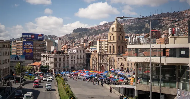 Explore the bustling market in La Paz, Bolivia, with its historic architecture and lively atmosphere.