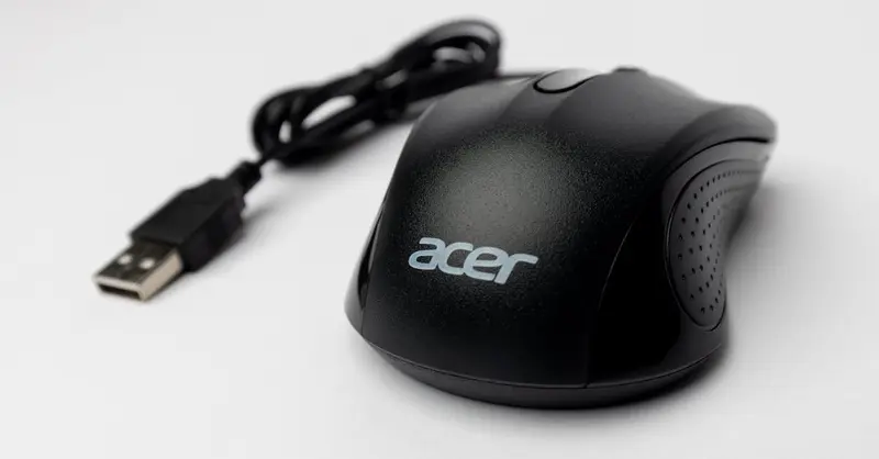 Close-up of a black computer mouse with USB cable on a white background.