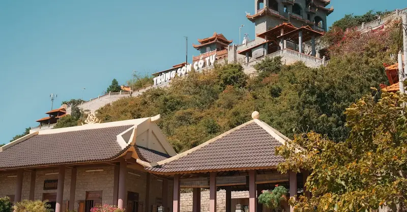 Trung Son Co Tu Pagoda on a sunny hillside, showcasing traditional architecture and vibrant natural surroundings.