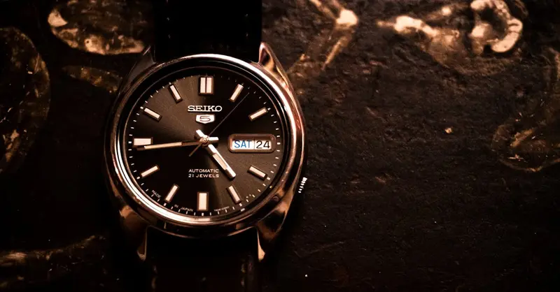 Close-up of a Seiko 5 automatic watch with leather strap, emphasizing elegance and precision.
