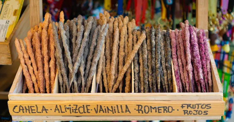 Vibrant display of assorted incense sticks with various scents in a wooden box.