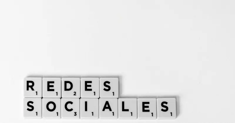Scrabble tiles spelling 'Redes Sociales' illustrating a social media concept on a white background.