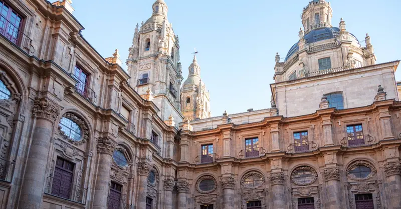 Beautiful architecture of the University of Salamanca, featuring ornate stonework and towers under a clear sky.