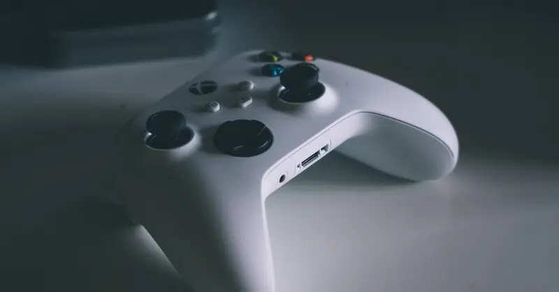 A detailed shot of a white gaming controller on a desk surface, perfect for tech and gaming themes.
