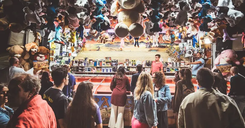 People enjoying games at a lively fair booth in Santiago de Compostela, Spain.