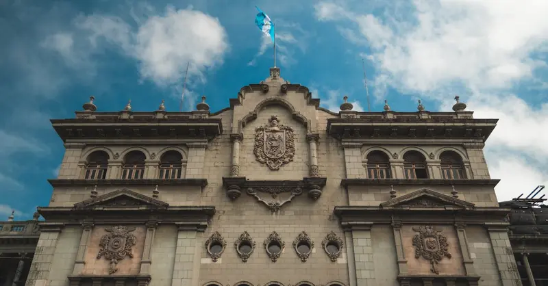 Stunning view of Guatemala's National Palace against a blue sky, highlighting its architectural beauty.
