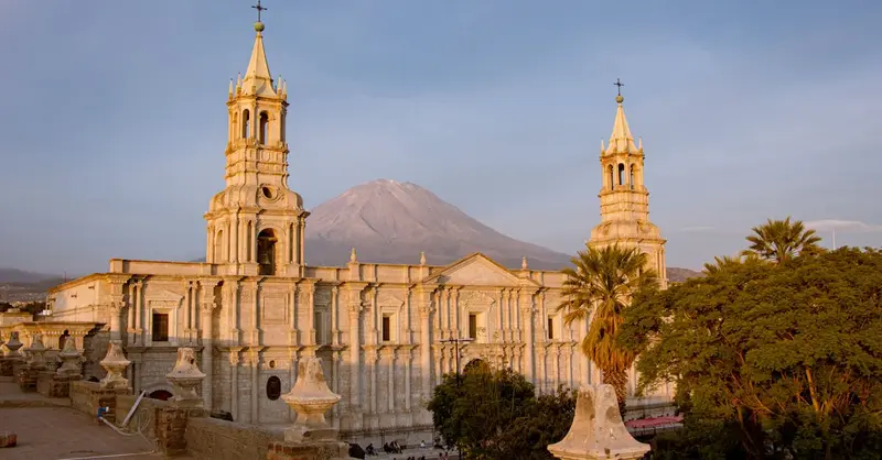 View of the Arequipa Cathedral in Peru with El Misti volcano in the backdrop during sunset.