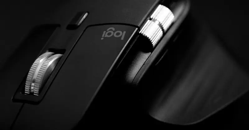 Close-up of a sleek, modern black gaming mouse with metallic scroll wheels.