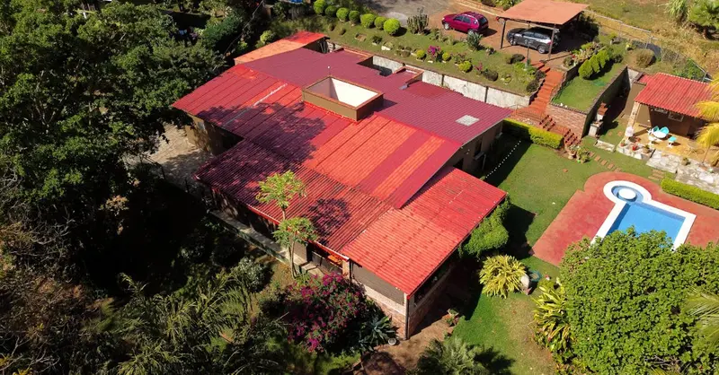 A stunning aerial shot of a house with a pool in San Salvador, surrounded by lush greenery.