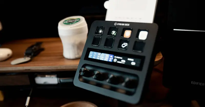 A Stream Deck on a wooden desk, featuring various buttons and controls in a home studio setup.