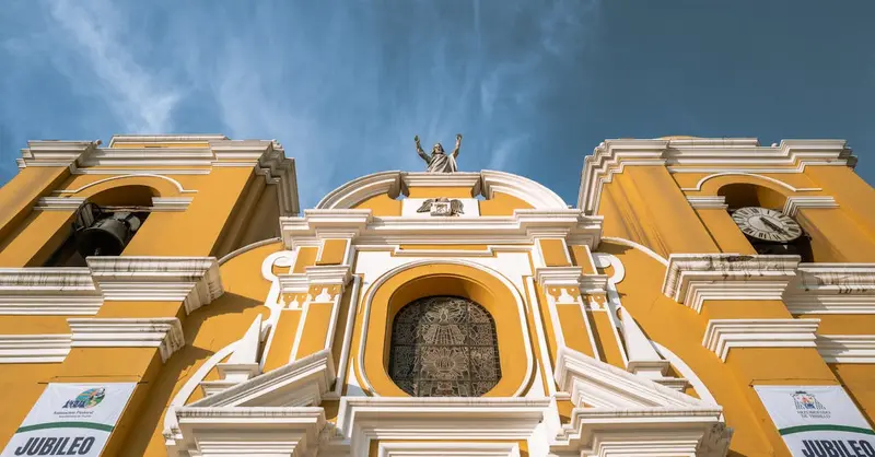 Vibrant yellow facade of Trujillo Cathedral with clear blue sky backdrop. Iconic landmark in Perú.