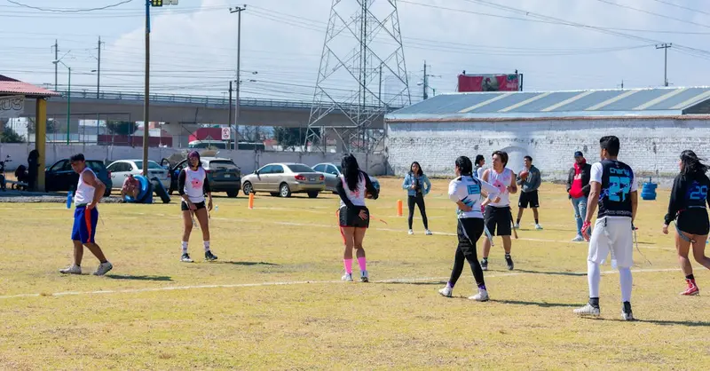 Vibrant scene of a youth flag football game in Toluca de Lerdo, Mexico, showcasing teamwork and outdoor sports.